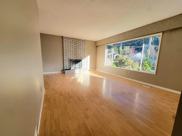 Unfurnished living room with a textured ceiling, light wood-style floors, and a fireplace