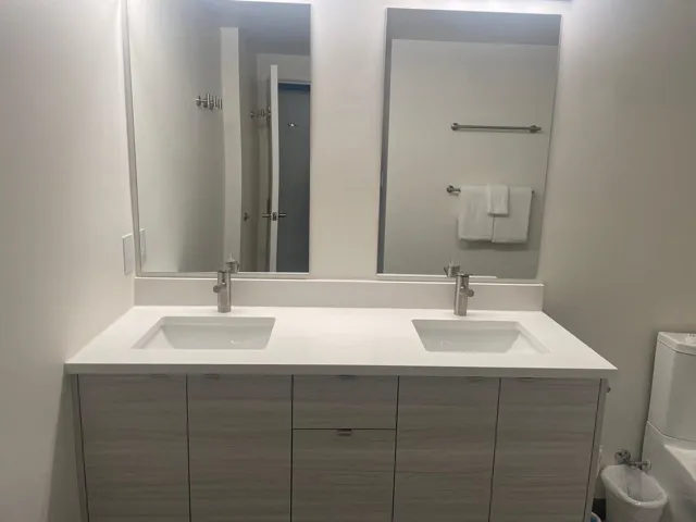 Full bathroom featuring double vanity and toilet