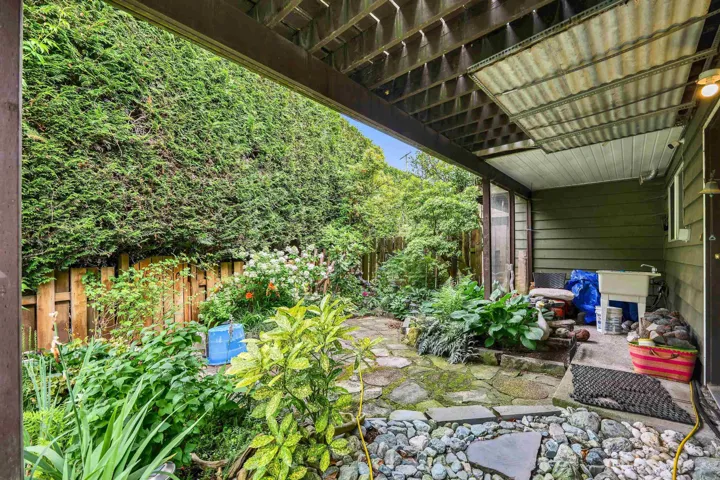 Covered patio area featuring a utility sink and a stone-paved walkway