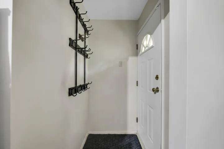 Entryway with a white paneled door featuring an arched transom window