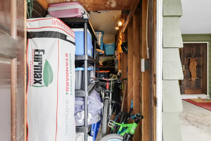 Expansive storage space with exposed wood framing, built-in shelving, and overhead lighting