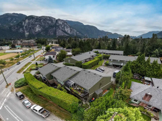 Aerial perspective showcasing multiple residential buildings with prominent mountain scenery
