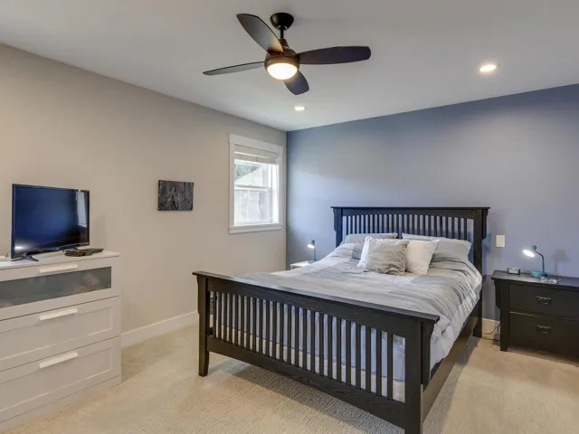 Bedroom featuring light colored carpet, ceiling fan, and recessed lighting