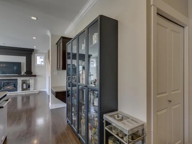 Hallway with dark wood-style flooring, ornamental molding, and recessed lighting