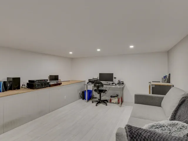 Office space with light wood-style flooring and recessed lighting