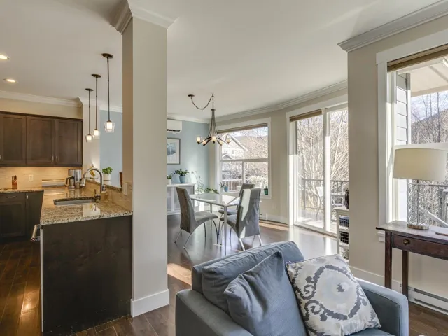 Living area featuring dark wood-type flooring, ornamental molding, and a chandelier