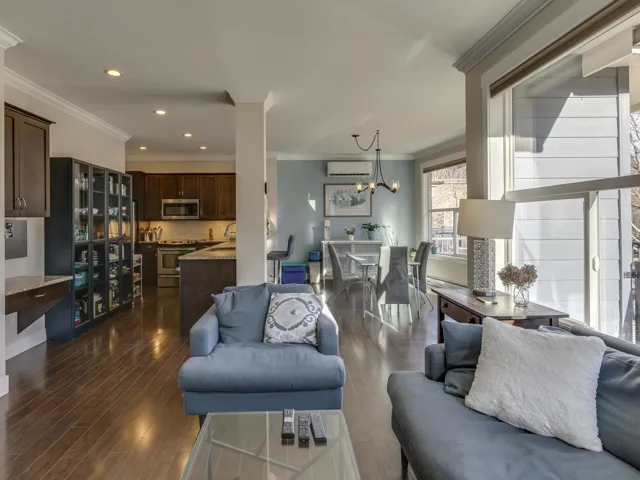 Living area with crown molding, dark wood finished floors, a chandelier, recessed lighting, and an AC wall unit