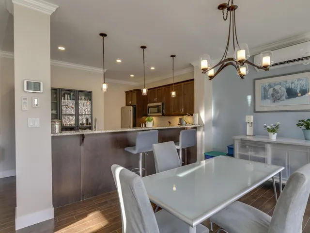 Dining area featuring wood finish floors, a chandelier, recessed lighting, crown molding, and a wall mounted AC
