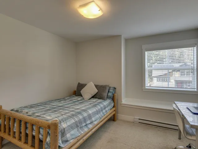 Bedroom featuring a baseboard heating unit and carpet