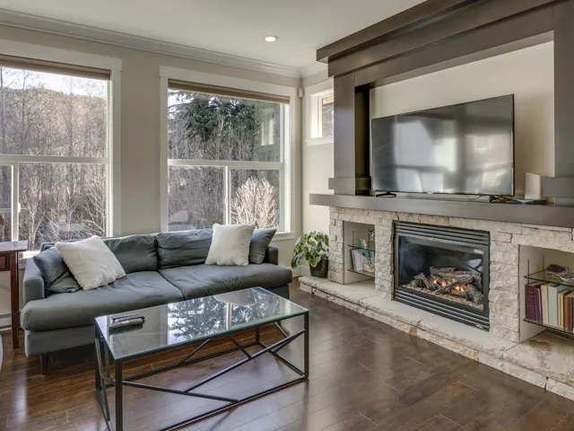Living room featuring dark wood finished floors, crown molding, and a fireplace