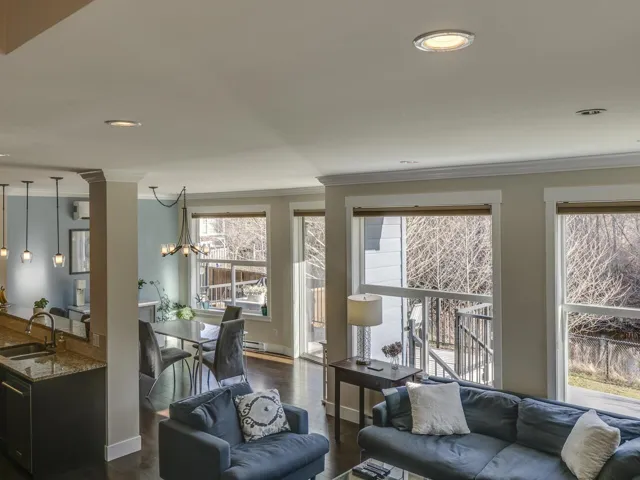 Living area with dark wood-style floors, ornamental molding, a chandelier, and recessed lighting