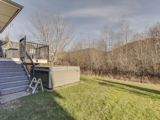 View of yard featuring a hot tub, stairs, and a deck
