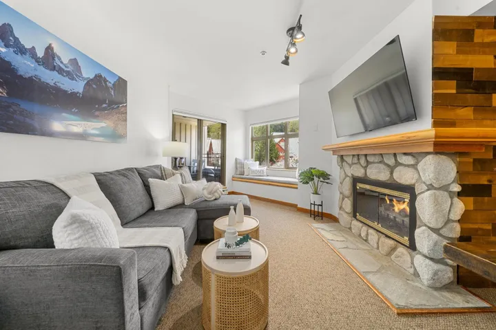 Living area featuring a stone fireplace with a wood mantel, an integrated window seat, and a sliding glass door leading to an outdoor space