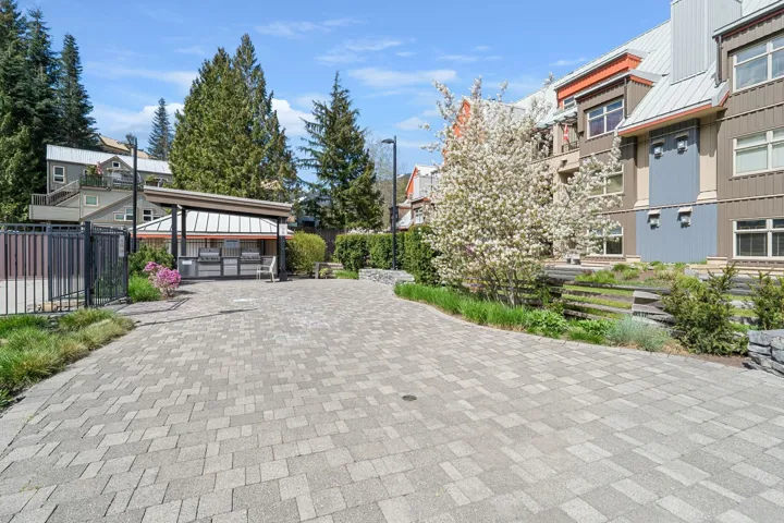 Paved patio area featuring a covered barbecue station with multiple grills
