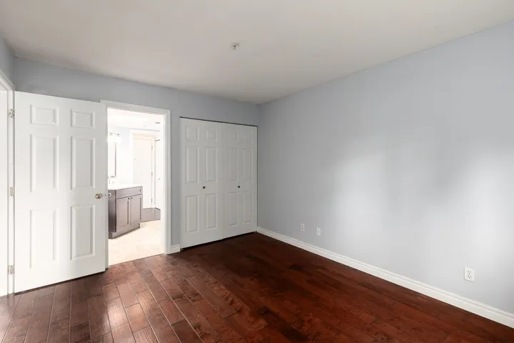 Interior room featuring wood-finish flooring, light blue walls, and white trim