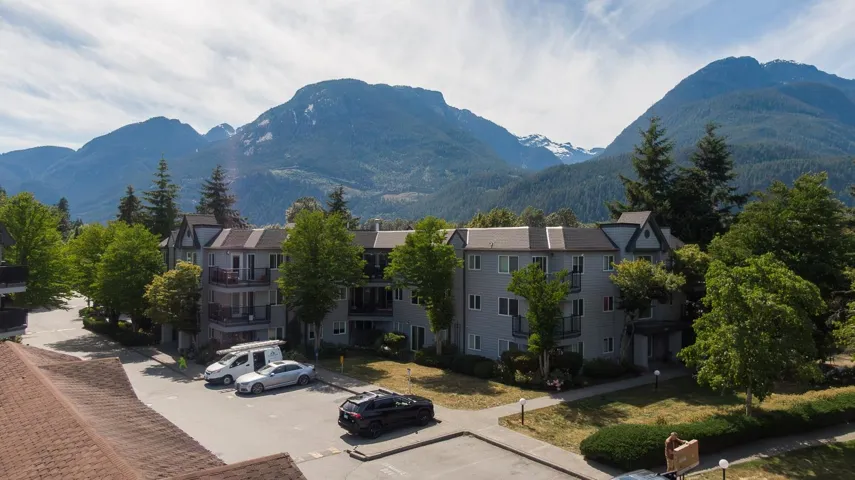 Multi-story residential buildings featuring private balconies and surrounding mature trees