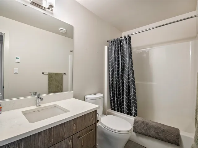 Full bathroom with toilet, vanity, and shower / bath combo