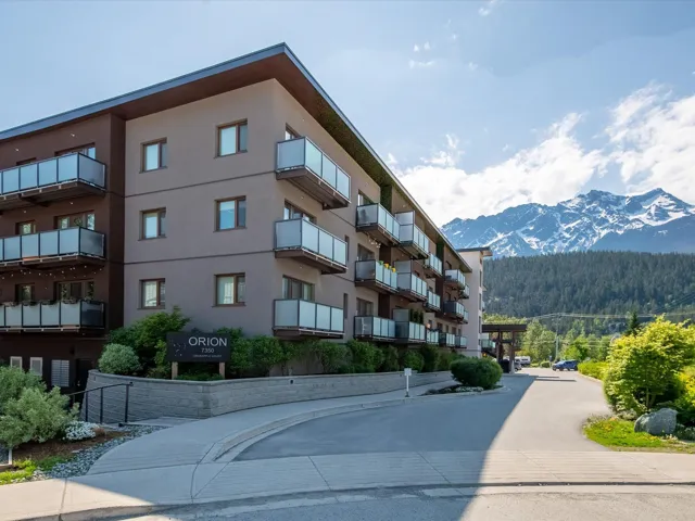 View of property with a wooded view and a mountain view