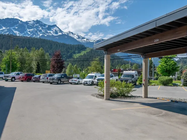 Partially covered parking lot featuring a mountain view and a view of trees