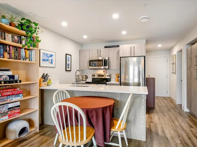 Kitchen featuring light countertops, a sink, appliances with stainless steel finishes, a peninsula, and light wood-style floors