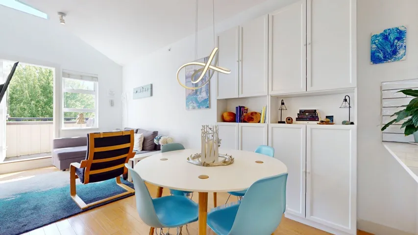 Dining area featuring light wood finished floors and lofted ceiling