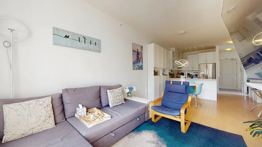 Living area with light wood finished floors and track lighting