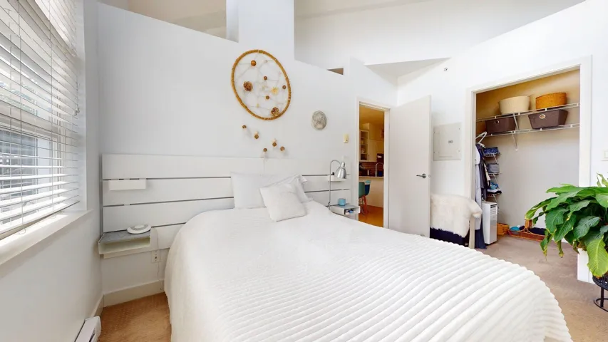 Bedroom featuring carpet flooring, a baseboard heating unit, electric panel, and a spacious closet