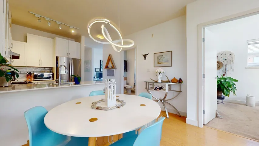 Dining area with light wood-style floors and rail lighting