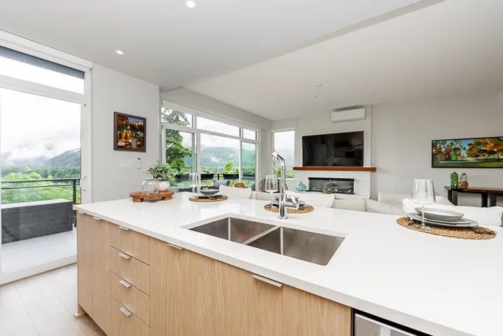 Kitchen featuring a sink, modern cabinets, light brown cabinets, light countertops, and recessed lighting