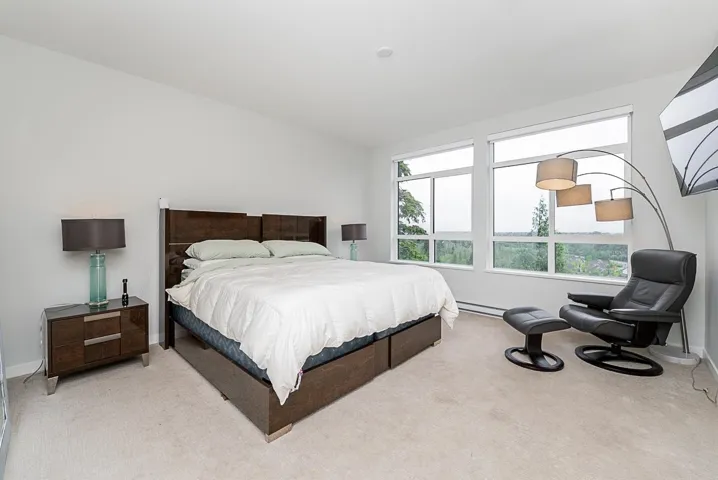 Bedroom featuring light carpet, baseboards, and baseboard heating
