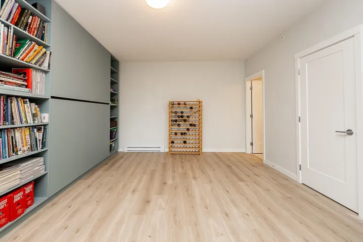Unfurnished room featuring light wood-style flooring and a baseboard radiator
