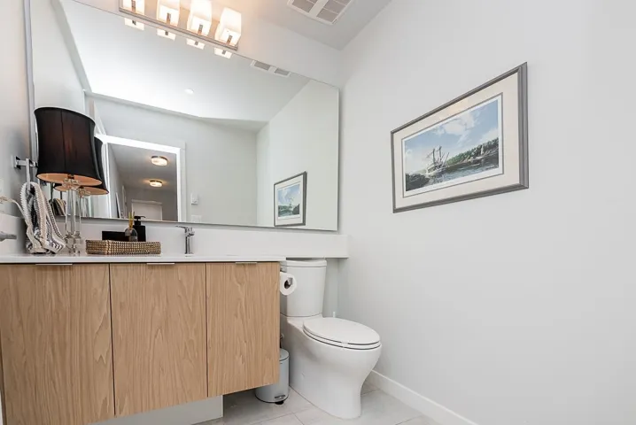 Bathroom with toilet, tile patterned flooring, vanity, and baseboards