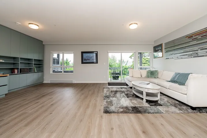 Living room with a baseboard radiator, light wood finished floors, and baseboards