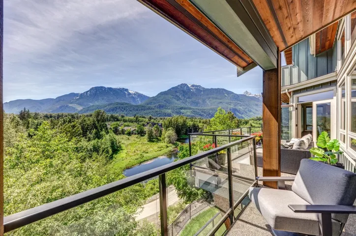 Expansive outdoor deck featuring a glass railing and a wood-paneled ceiling