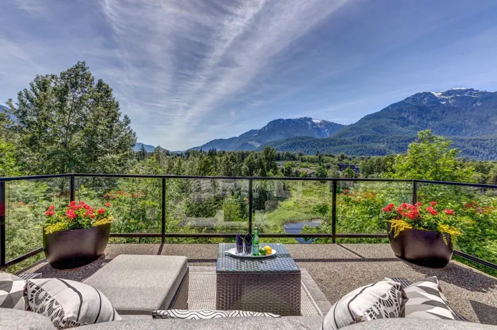 Spacious outdoor patio with glass railing and durable stone-finish flooring