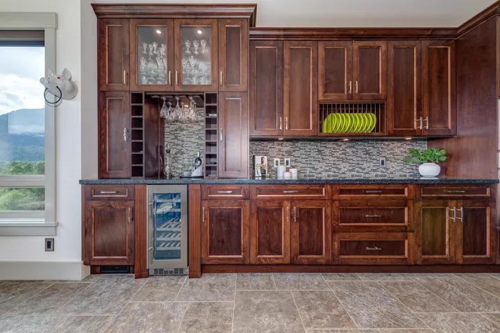 Custom cabinetry featuring glass-front display cabinets, integrated wine storage, and a built-in beverage cooler