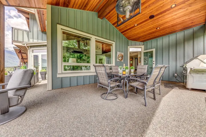 Covered patio with an exposed aggregate surface, featuring a wood-finish ceiling with recessed lighting