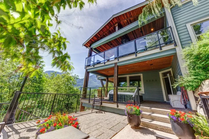 Multi-level exterior featuring a ground-level patio and two upper-level decks