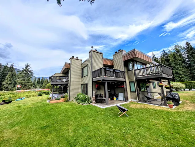 Back of property with a patio area, a yard, and a deck