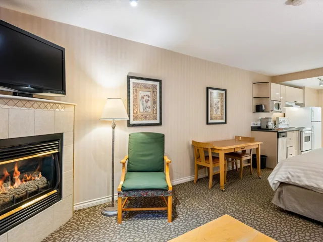 Bedroom featuring dark colored carpet, a tile fireplace, and wallpapered walls