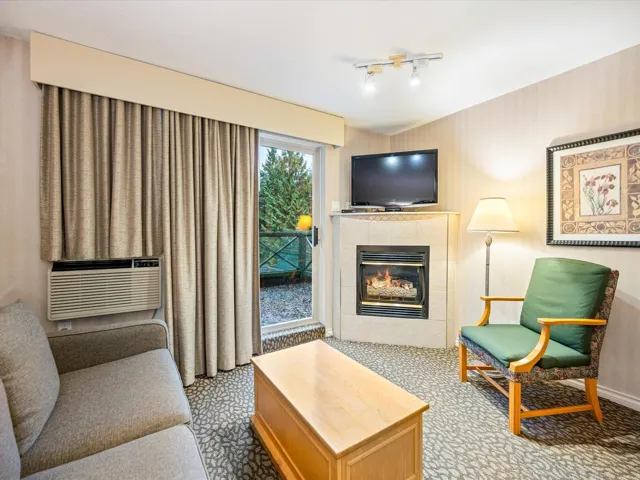 Carpeted living room featuring a tiled fireplace and cooling unit