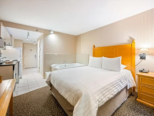 Bedroom with wallpapered walls and light tile patterned flooring