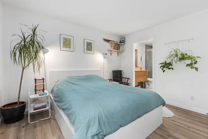 Bedroom featuring wood finished floors and ensuite bath