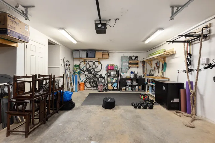 Garage featuring a garage door opener, a heating unit, and a workshop area