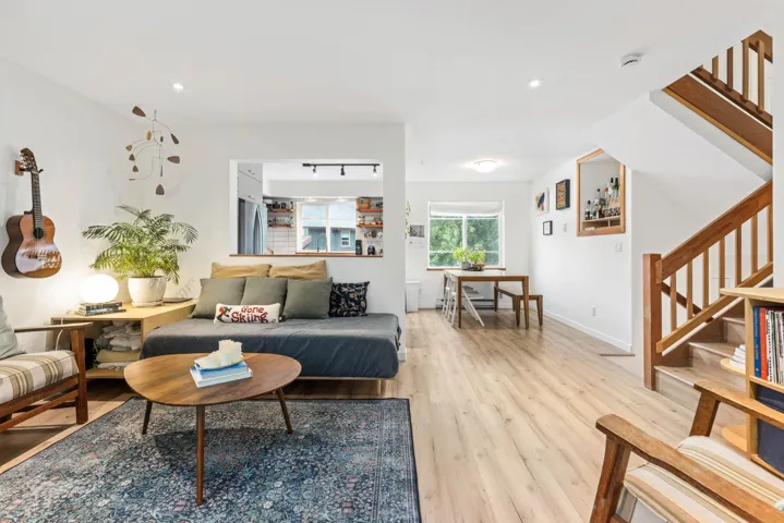 Living room with stairs, light wood finished floors, and recessed lighting