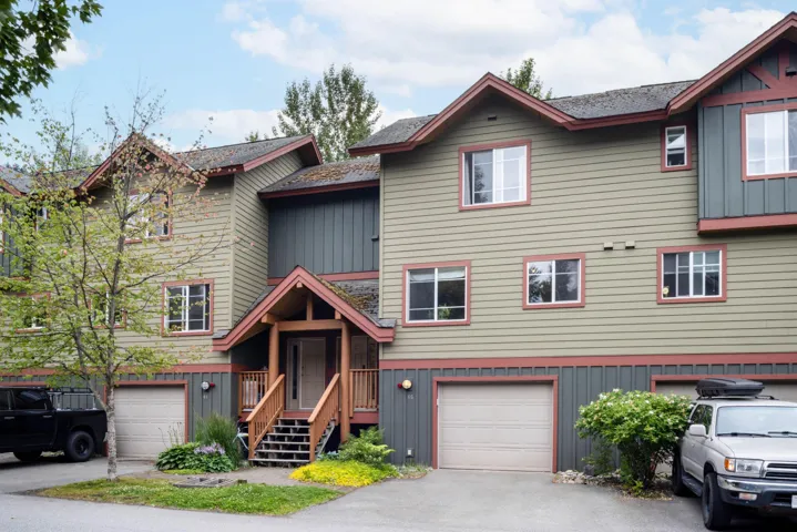 View of property featuring a garage, board and batten siding, and driveway