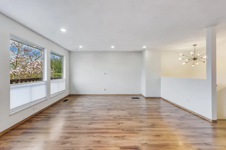 Spare room featuring recessed lighting, light wood-style flooring, baseboards, and an inviting chandelier