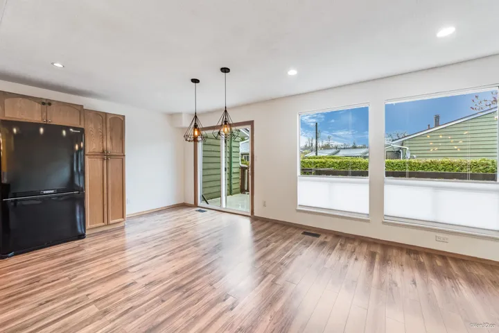 Kitchen featuring freestanding refrigerator, an inviting chandelier, visible vents, hanging light fixtures, and light wood finished floors