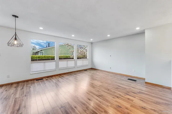 Unfurnished living room with light wood-style floors, baseboards, visible vents, and recessed lighting