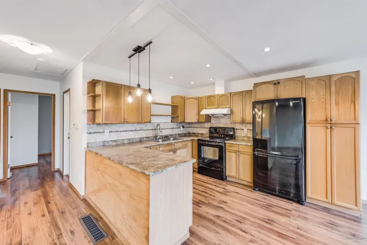 Kitchen with visible vents, open shelves, a sink, under cabinet range hood, and black appliances